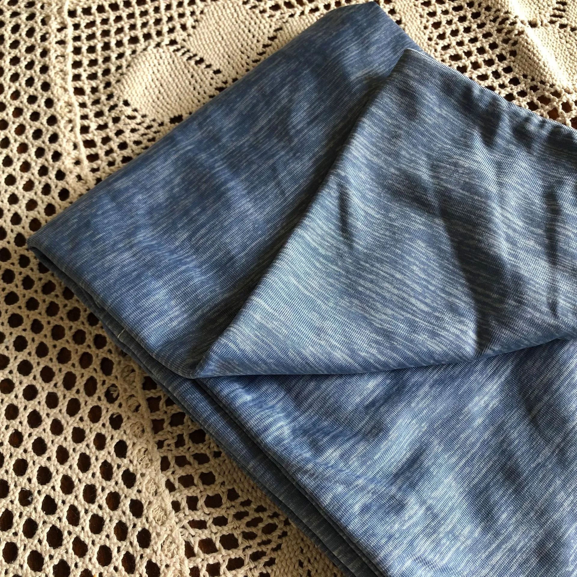 Blue and grey cooling blanket with Japanese Q-Max fibres on a bed.