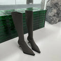 Black pointed toe women's below-the-knee boots with stiletto heel and back zipper fastening.