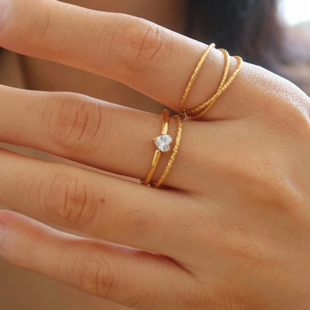 Golden stainless steel ring showing love heart and oval shape options, displayed next to size markers 5, 6, 7, 8.