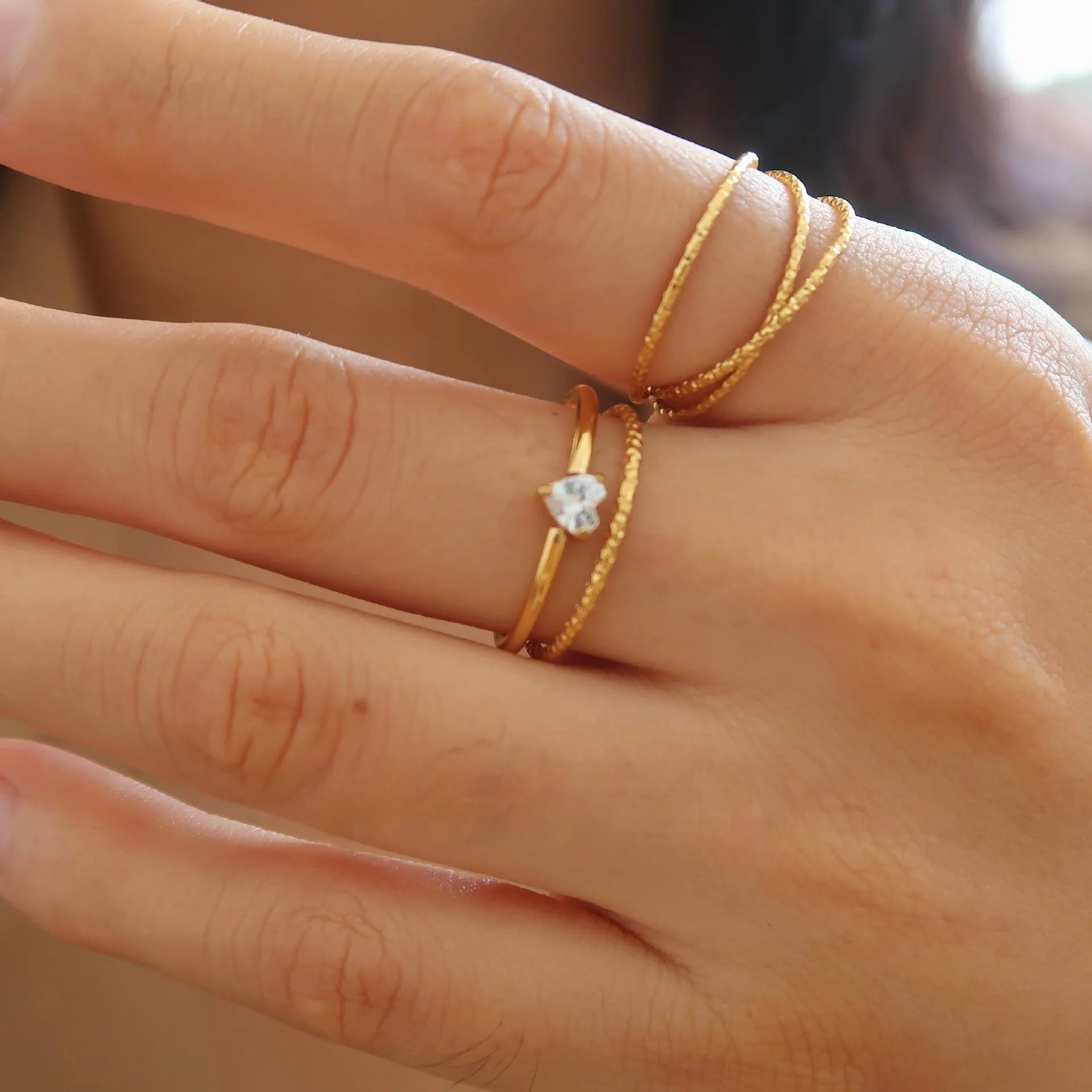 Golden stainless steel ring showing love heart and oval shape options, displayed next to size markers 5, 6, 7, 8.