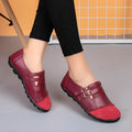 A pair of casual black flat shoes with a round toe, Velcro strap, and cow split leather upper.