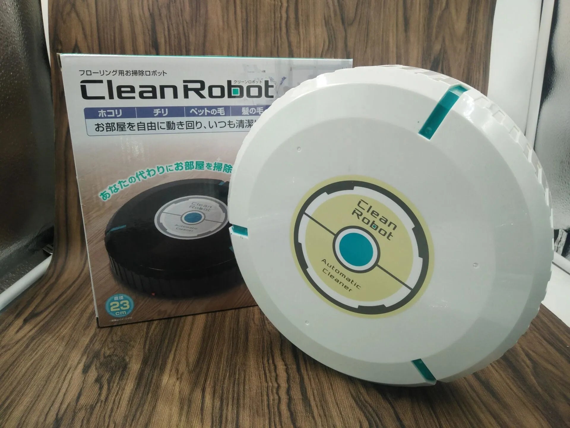 Black and white ABS plastic robot floor sweeper automatic cleaner on wooden floor