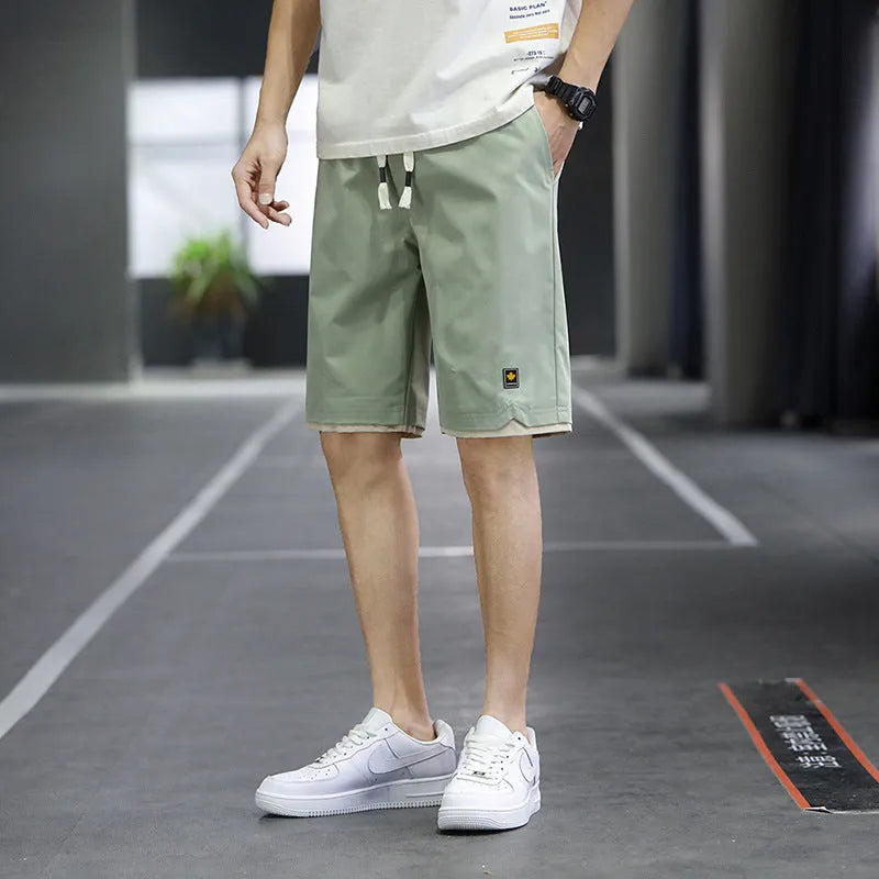 Man's loose-fitting straight-leg beach shorts in green on a neutral background.