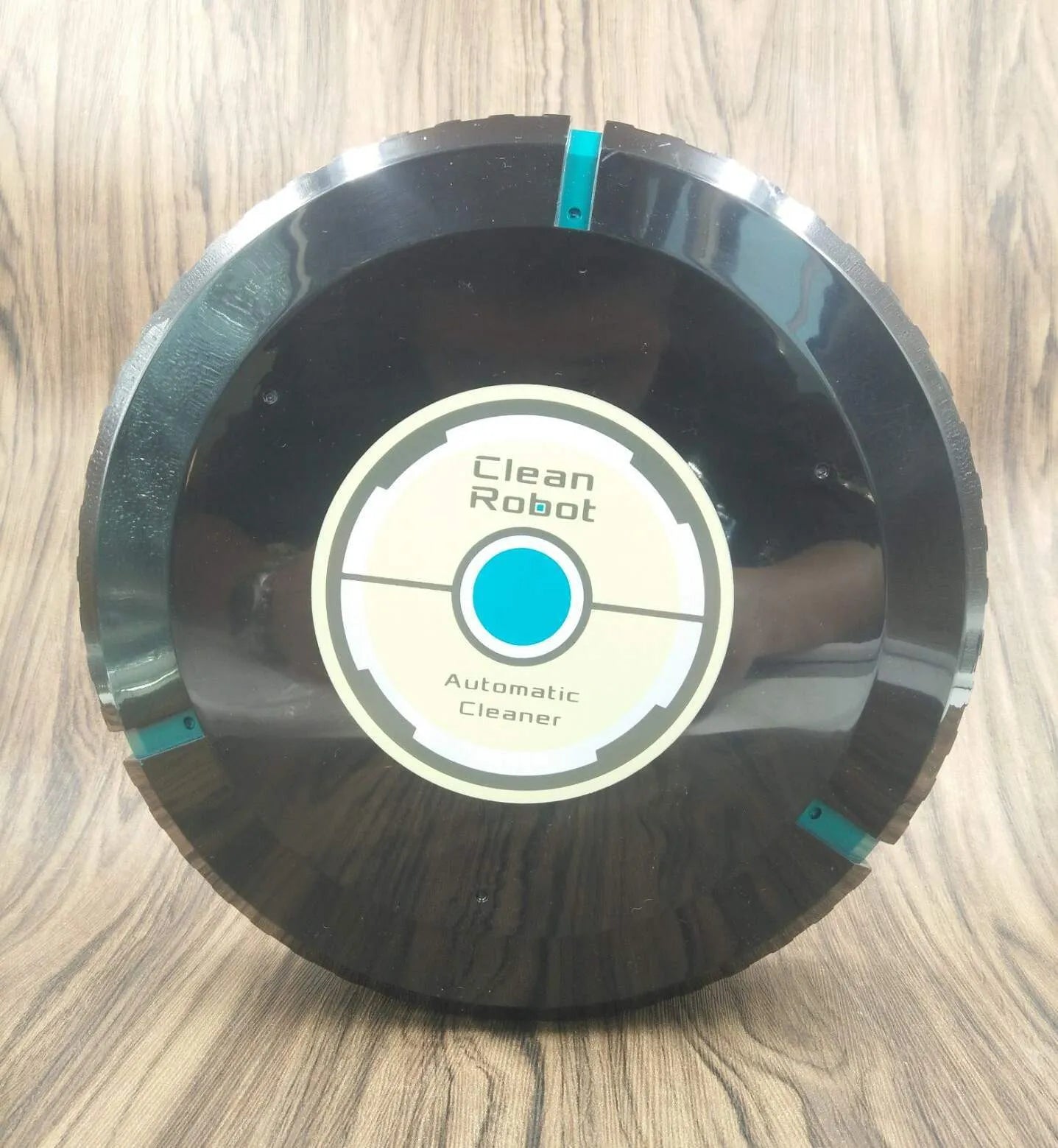 Black and white ABS plastic robot floor sweeper automatic cleaner on wooden floor
