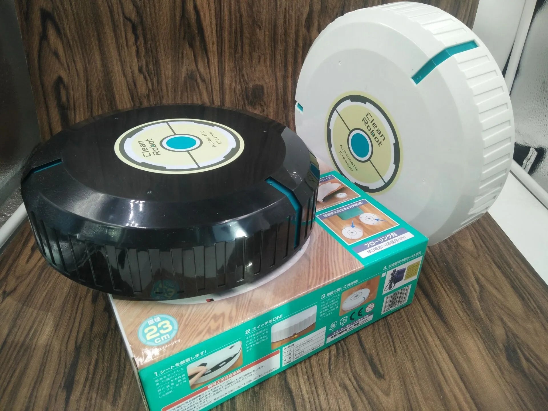 Black and white ABS plastic robot floor sweeper automatic cleaner on wooden floor