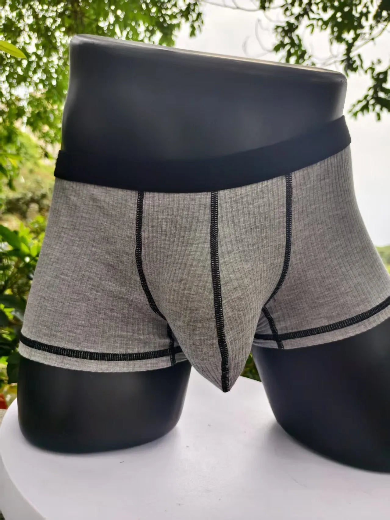 Solid colour men's boxers on a white background, showing thin breathable fabric and body-shaping fit.