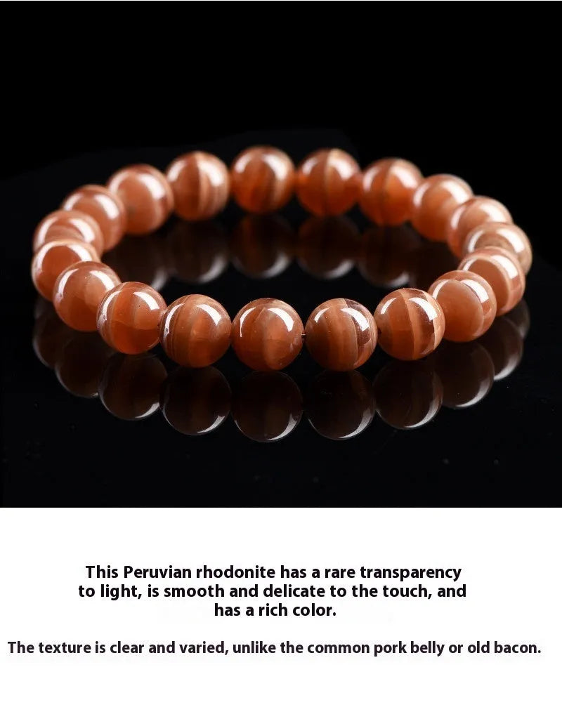 Natural rhodochrosite round bead bracelet with ruyi design on wrist.