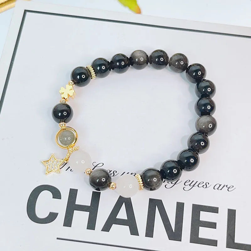 Adjustable silver stone bracelet for women with choice of flower, love, or star charm on a white background.
