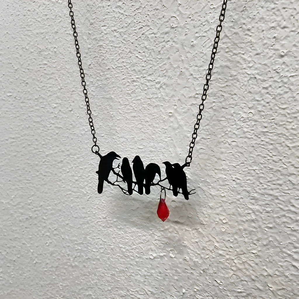 Black electroplated alloy crow pendant necklace on a cross chain for women.