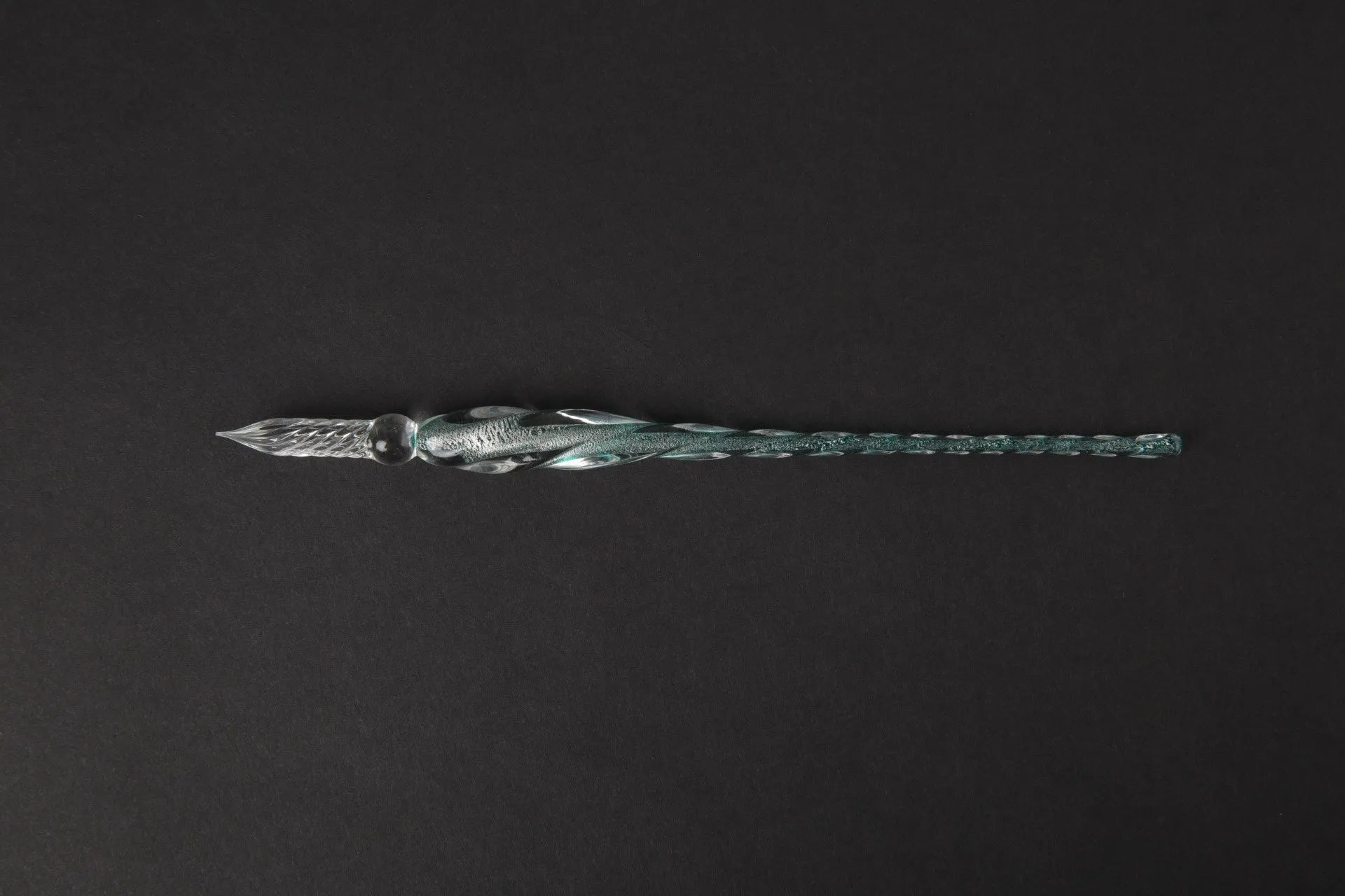 Hand-blown glass crystal pen with coloured ink in a transparent barrel on a gift box.