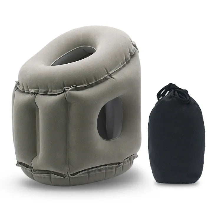 Grey inflatable sleeping pillow with flocking surface deflated on surface with storage bag