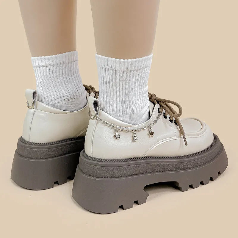 White platform Mary Jane shoes with chunky heel and metal decorations on display