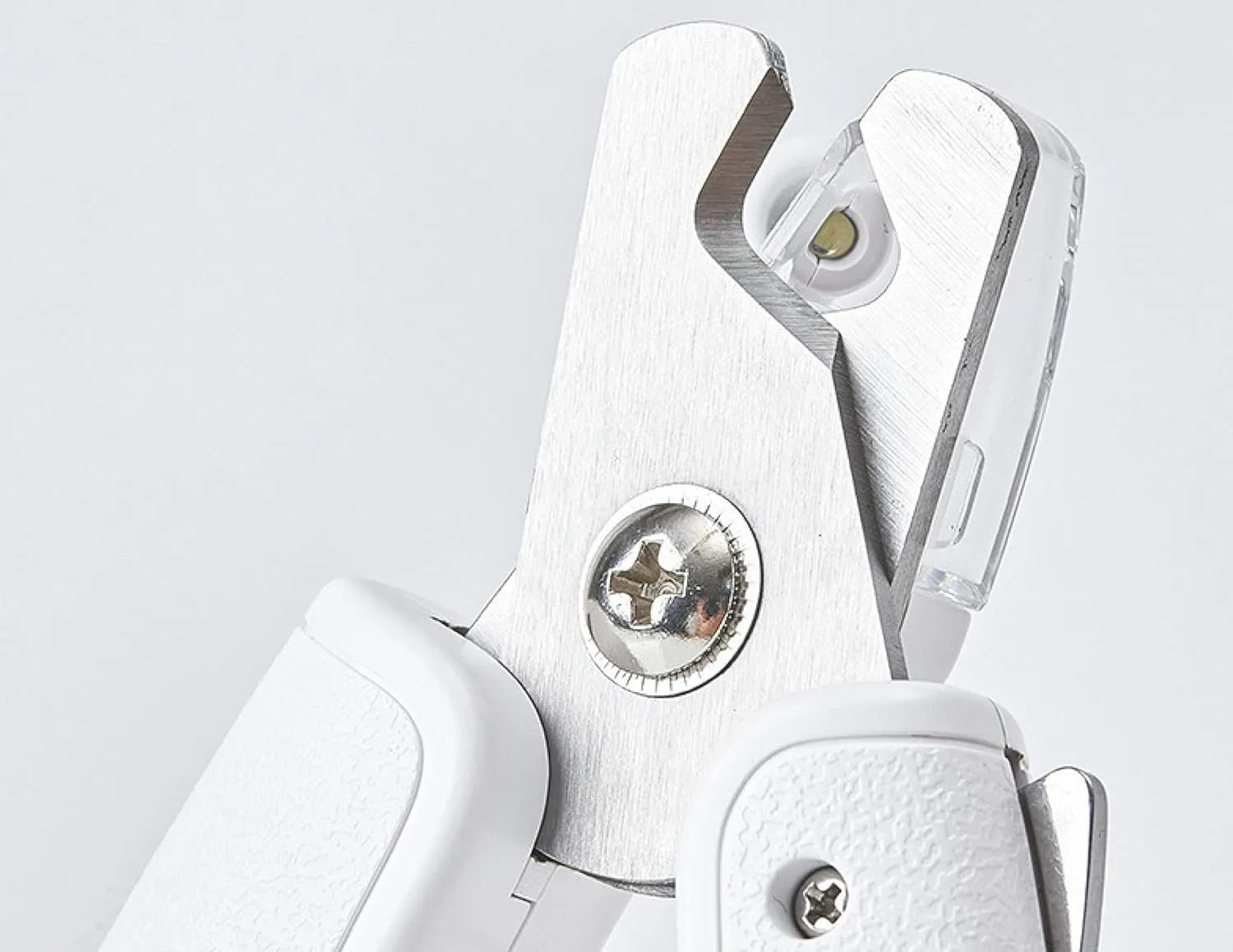 White pet nail clippers with LED light, anti-splash guard, and a nail file on a table.