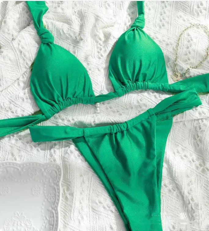 Pink women's bikini with a knotted top, split straps, and matching briefs on a neutral background.