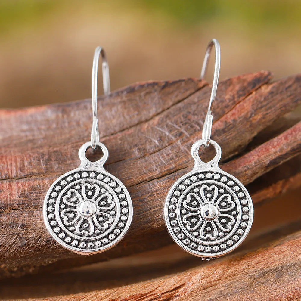 A pair of geometric zinc alloy earrings with a round distressed ethnic print in Bohemian retro style.