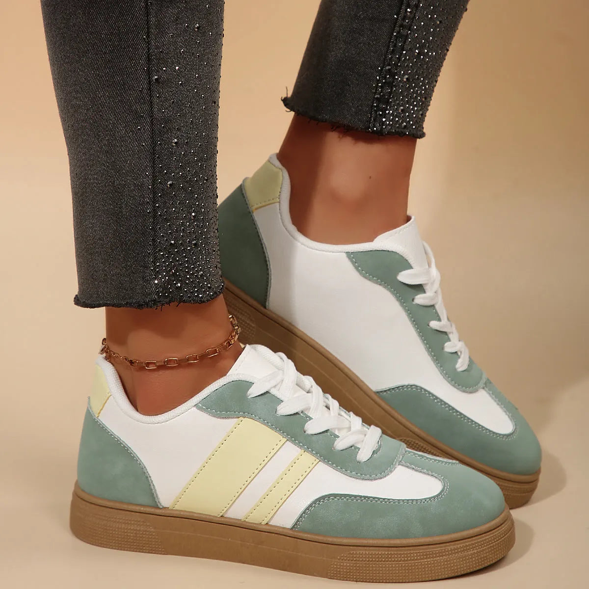 Green women's retro trainers with a cross strap design, round toe, and white rubber sole.