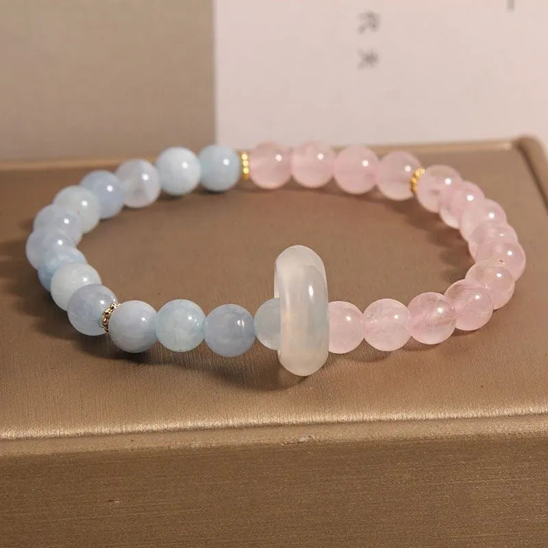 Aquamarine crystal bracelet with mixed materials including pink beads, white pearls, and peach blossom elements