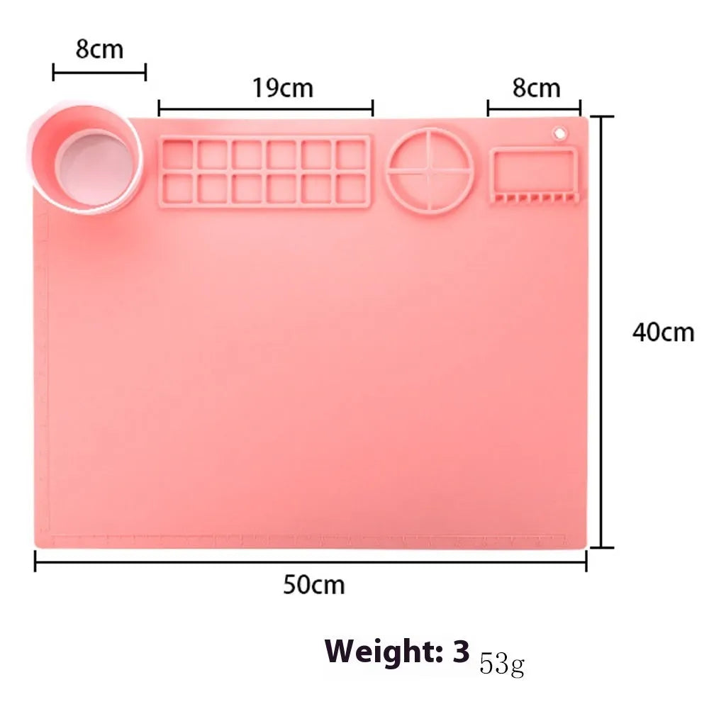 Light blue silicone painting mat with two mixing bowls, measuring 50cm by 40cm on a wooden table.