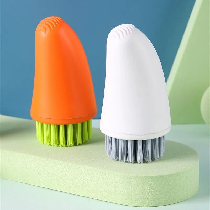 Orange and white carrot-shaped kitchen brush with nylon bristles for scrubbing.