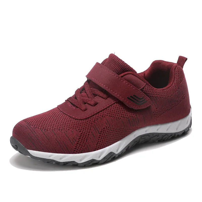 Women's low-top sneakers with Velcro straps and a wedge heel, in a mesh upper and solid colour.