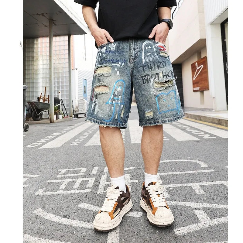 Blue men's ripped denim shorts with graffiti details and straight-leg cut