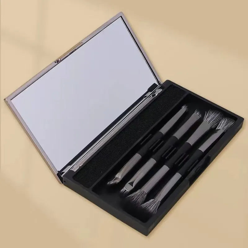 Compact makeup brush set with mirror showing silver or gold finish brushes with artificial fibre heads
