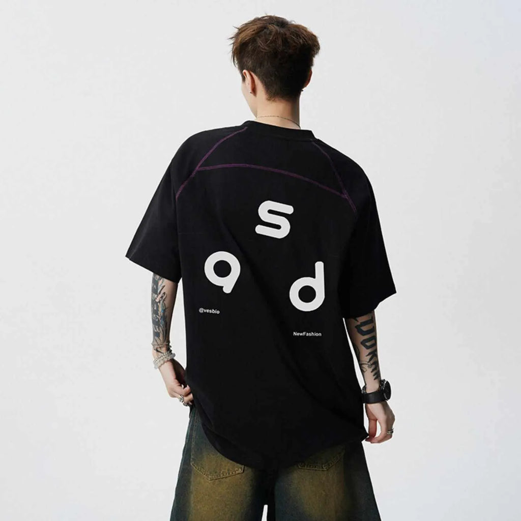 Man wearing a loose-fit black cotton t-shirt with a white letter print on the chest.