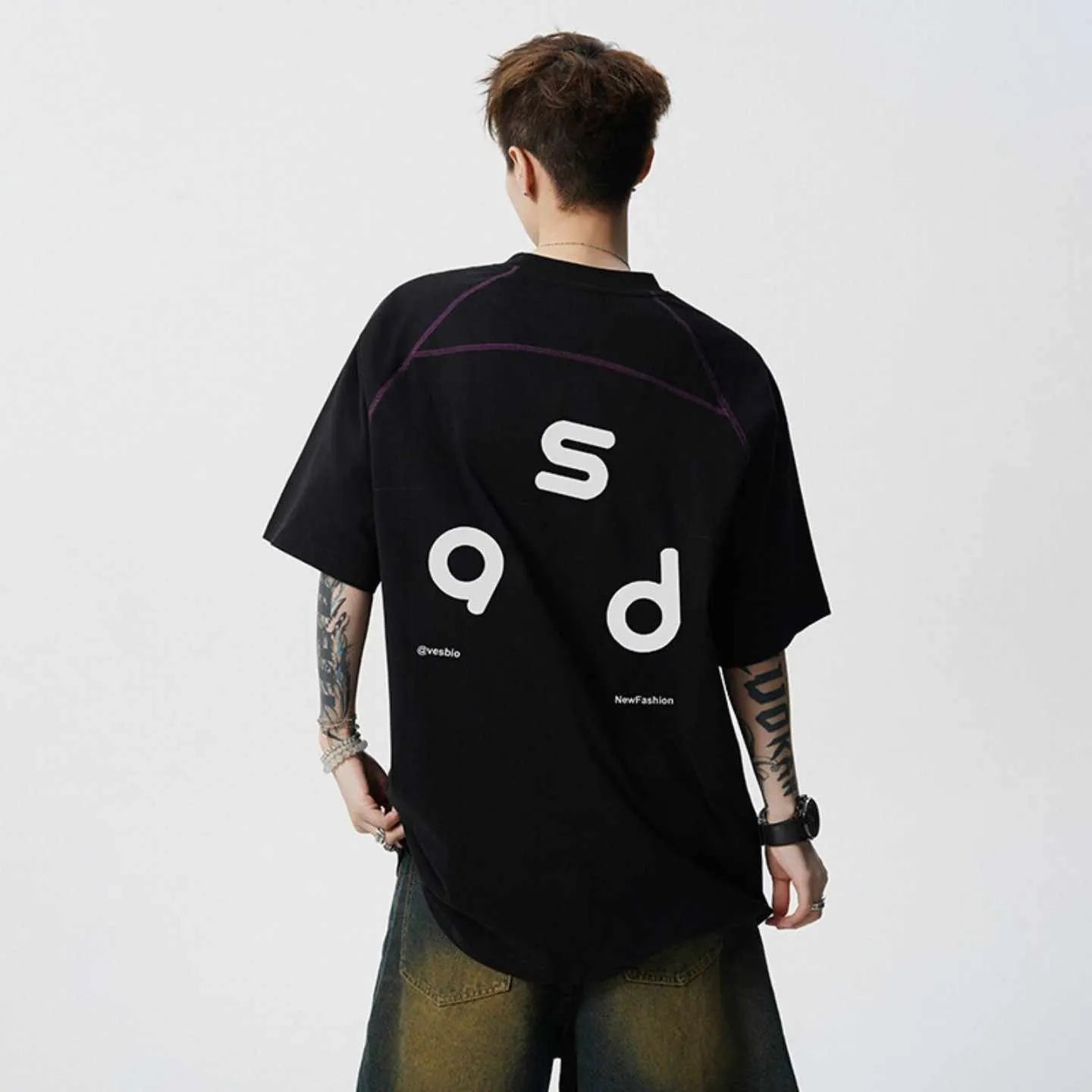 Man wearing a loose-fit black cotton t-shirt with a white letter print on the chest.