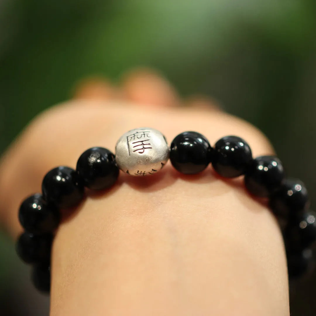 Black agate bracelet with 10mm beads and sterling silver clasp on wrist