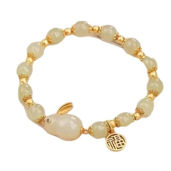 Women's black bracelet with green jade hare charm, fu character, and lily motif detail.