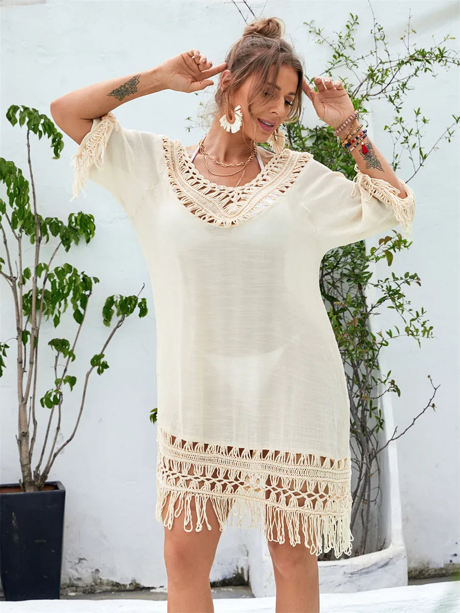 Apricot-coloured hand-crocheted long beach dress for women on a hanger.