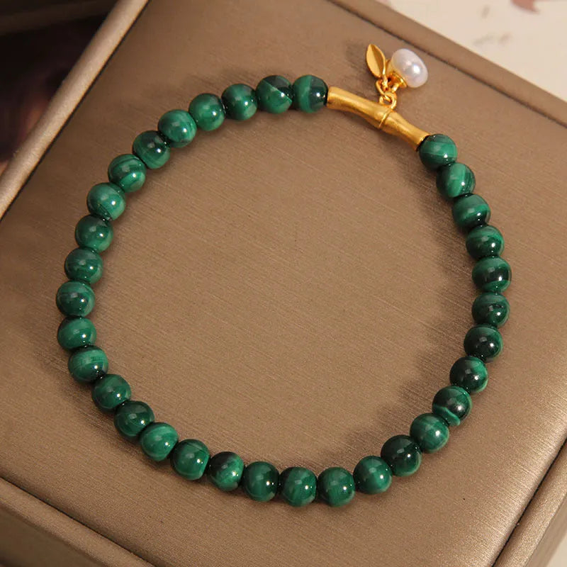 Close-up of a women's white crystal bracelet with a raised lucky bamboo design on the wrist.
