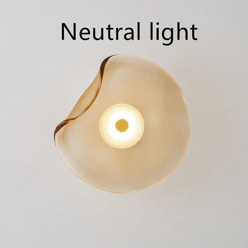 Round glass wall lamp in a choice of colours for bedroom bedside lighting.