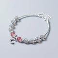 Natural moonstone bracelet with round beads, a crescent moon charm, and an adjustable silver chain on a wrist.