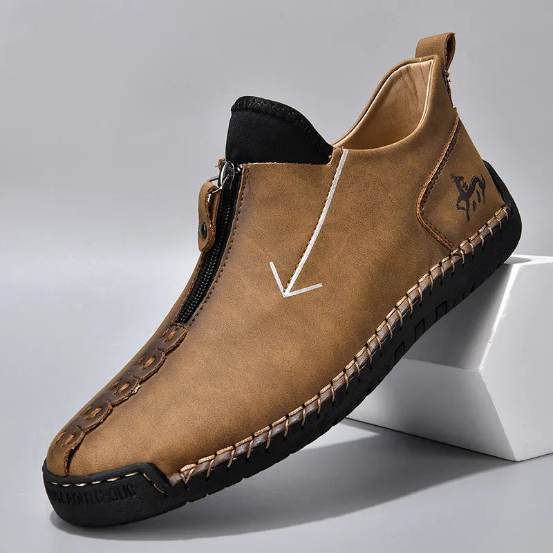 Men's black front-zip casual boots with round toe and low heel, showing the side zipper and rubber sole.