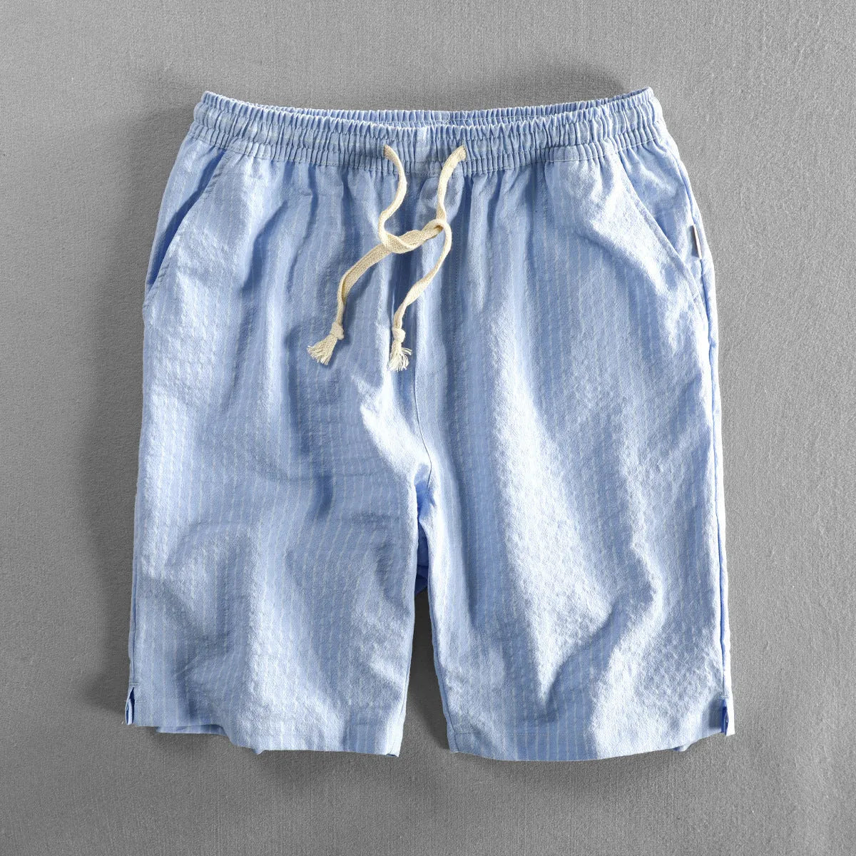 Man wearing black and white striped cotton casual shorts with a loose straight leg and elasticated waist.
