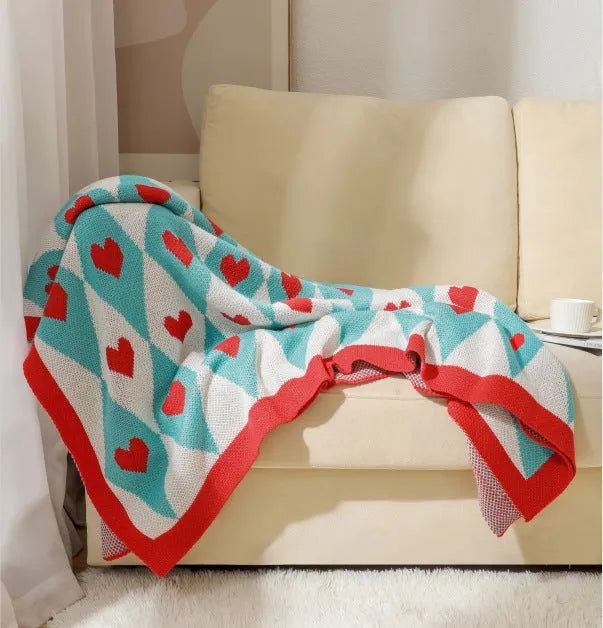 Acrylic sofa blanket with tassels in geometric pattern colour option on a sofa