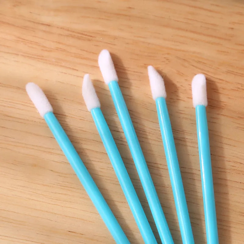 Pack of disposable lip brush wands with flocked brush tips and coloured handles.