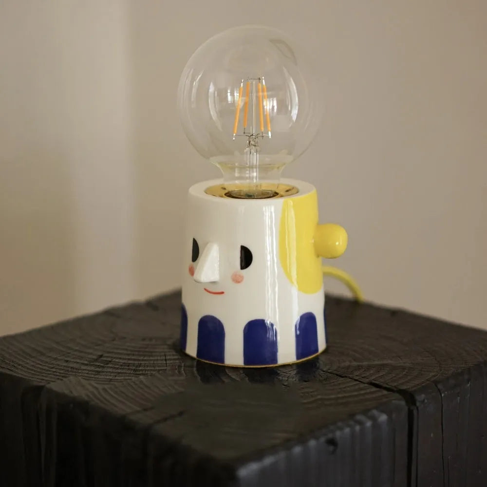 Handmade ceramic table lamp with ball headlight design on wooden surface