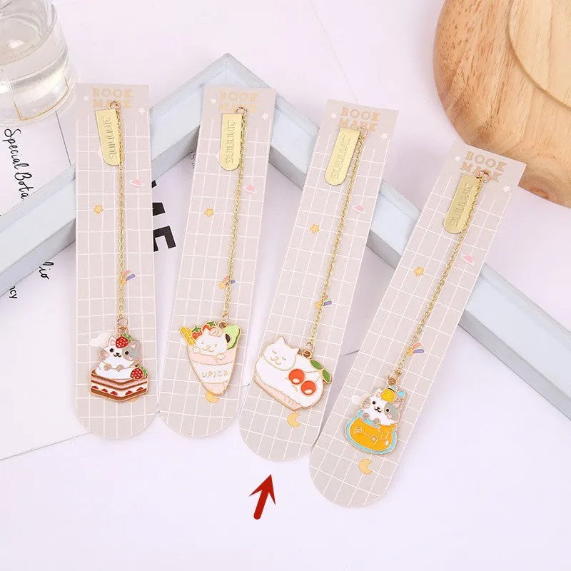 Metal cartoon cat bookmark with food-themed designs including strawberry cake and fruit roll styles