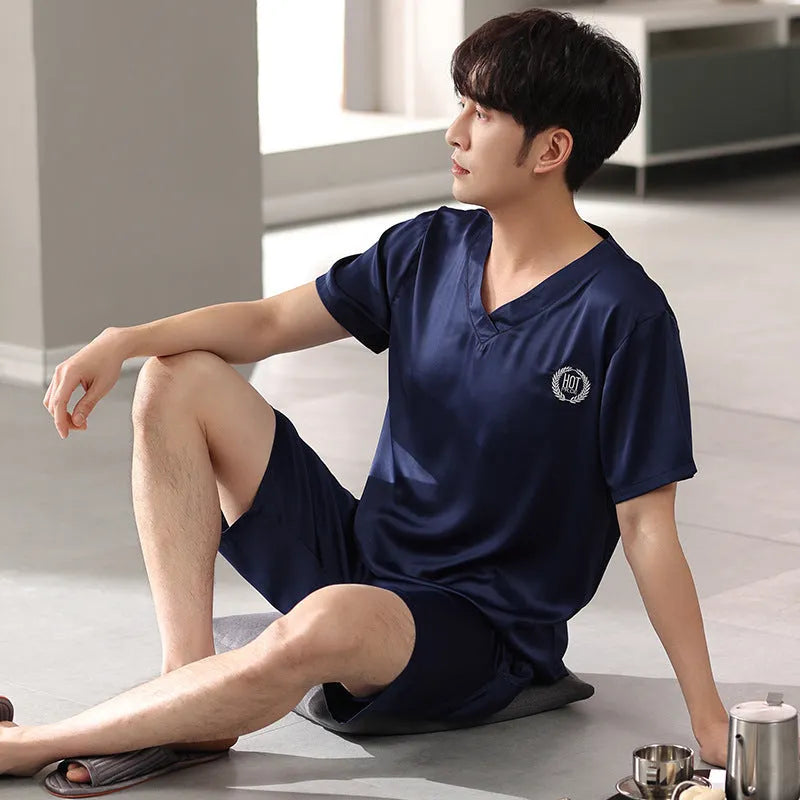 Man wearing a light grey ice silk short-sleeve pajama shirt and matching loose shorts.