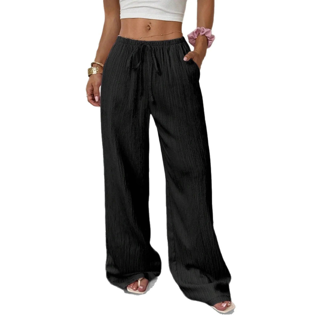 Women's black wide-leg trousers with a white lace-up detail at the mid waist on a hanger.