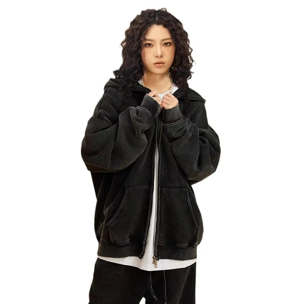 Man wearing a washed black fleece-lined hooded cardigan sweater with a double zip.