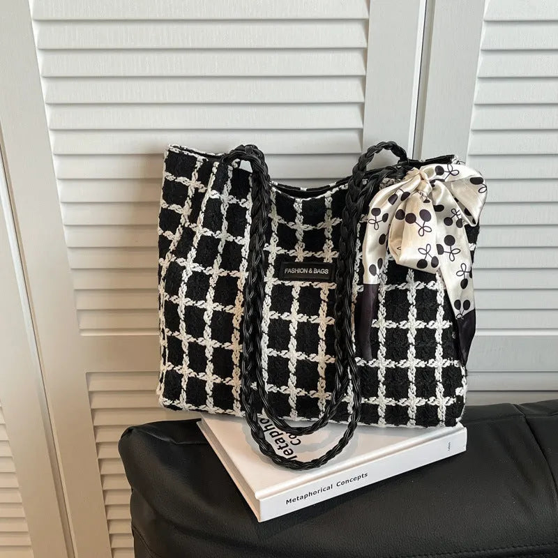 Black woven wool shoulder bag showing internal organisation with phone pocket, document section and zipper compartment