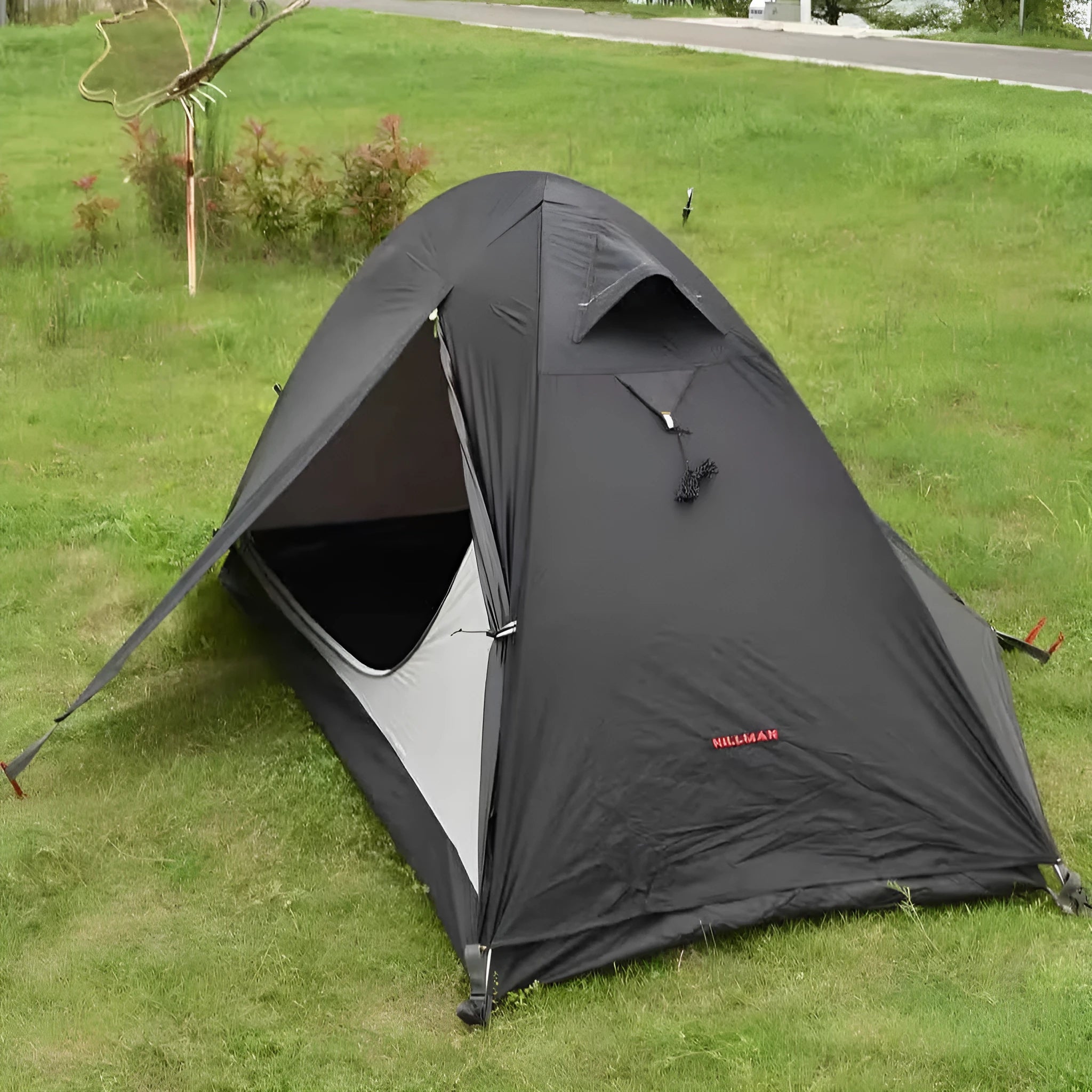 Black single person double account tent with aluminium poles set up outdoors