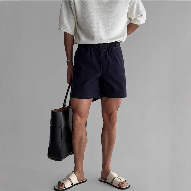 Men's loose-fit cotton sports shorts in khaki colour on a white background.