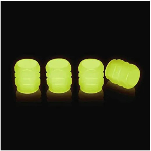 Pack of green and blue luminous rubber tyre valve caps on a car tyre valve.