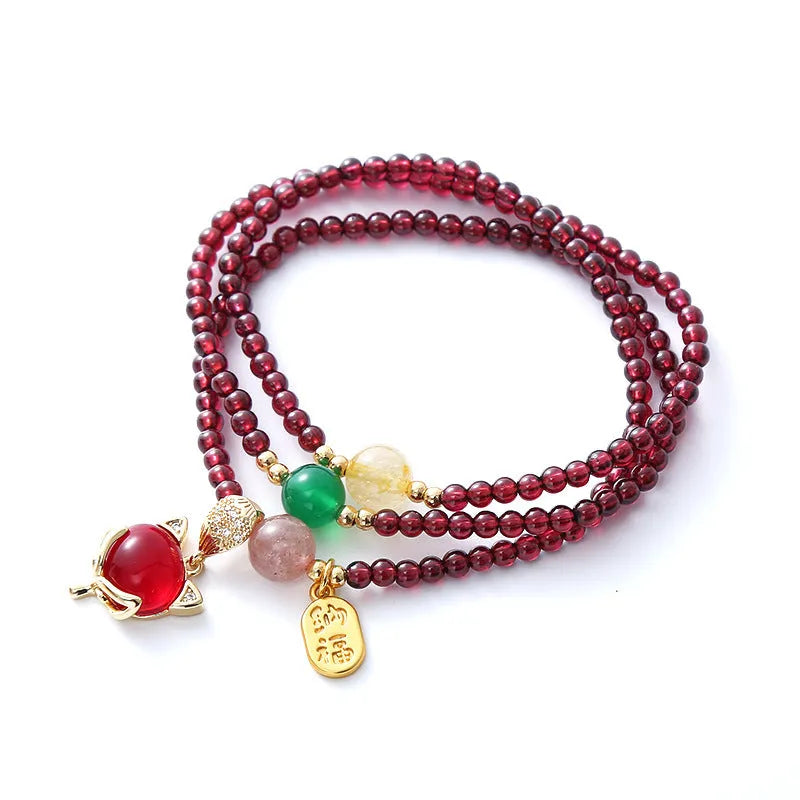 Purplish red rope bracelet with a detailed natural garnet fox pendant and adjustable tie closure.