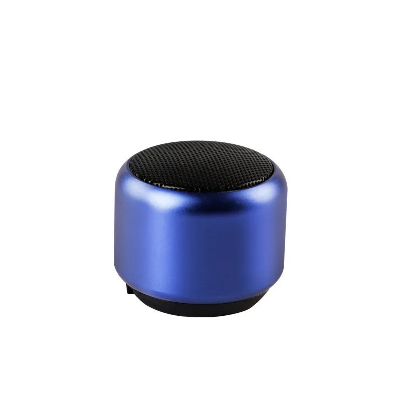 A small portable Bluetooth speaker shown in one of four colour options: black, blue, gold, or pink.