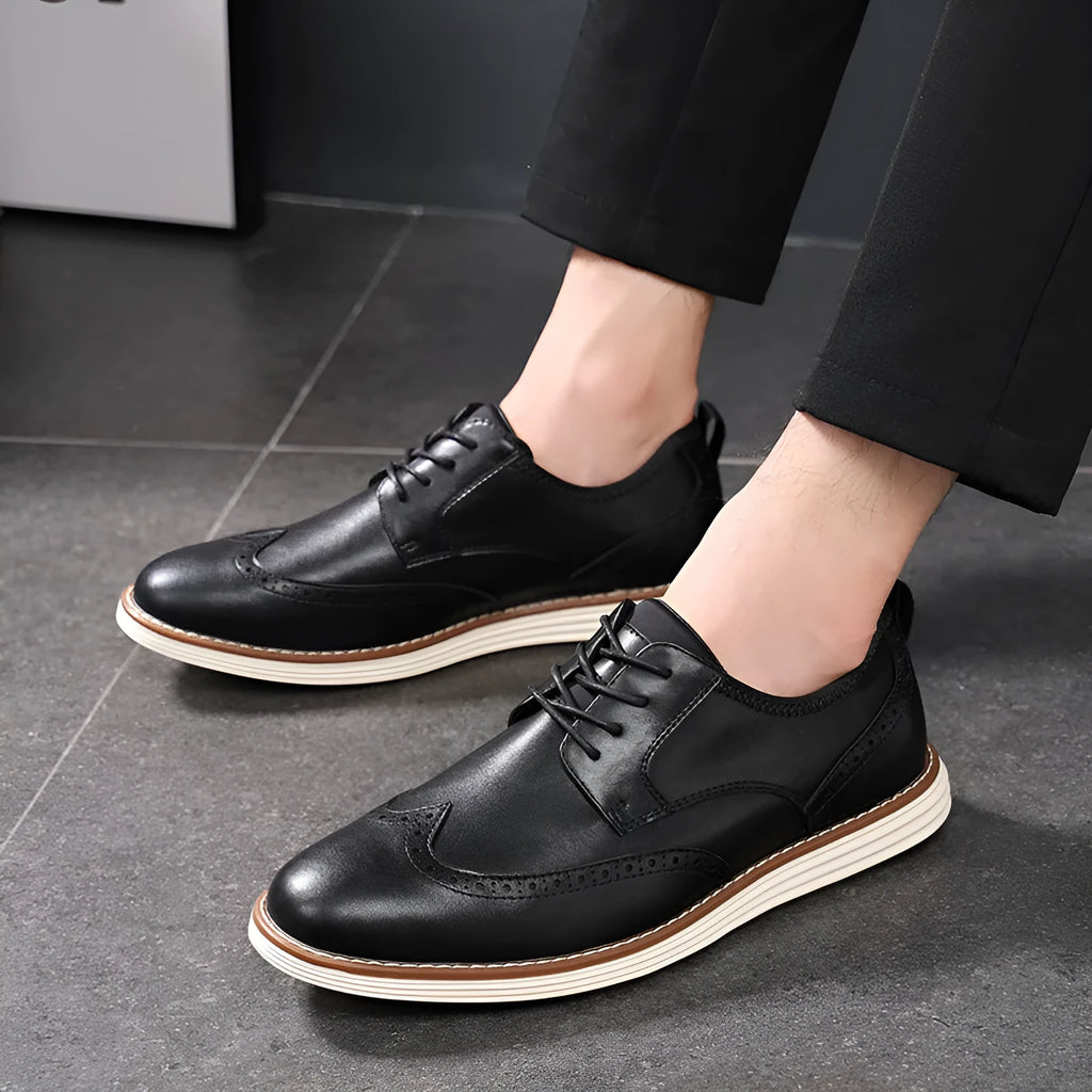 Men's black slip-on casual shoe with round toe and carved detail on the PU upper.
